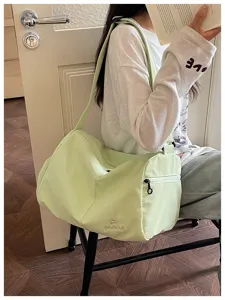 Casual light green shoulder travel gym bag detail showing large capacity and front pocket.