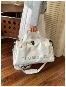 White gym duffel bag for sports and travel, featuring durable leather and practical storage design.