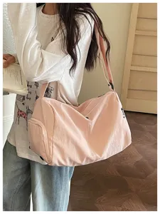 Detailed view of the pink canvas duffel bag, showing large capacity and crossbody strap.