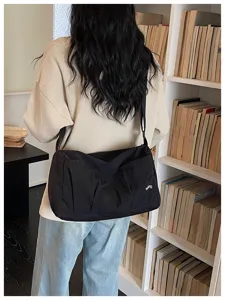 Detail view of the minimalist black travel shoulder bag showcasing large capacity and strap.