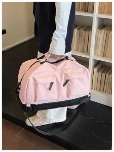 Primo piano dettagliato della borsa da viaggio rosa con tasche anteriori e scomparto.