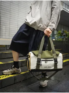 Details der multifunktionalen Reisetasche mit Fareblock-Design, Riemengriffen und Schnallen.