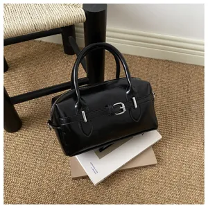 Elegante schwarze Bowlingtasche aus Kunstleder mit Schnalle und Griffen oben.
