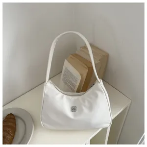 Detail view of the white minimalist underarm bag featuring a unique silver flower logo