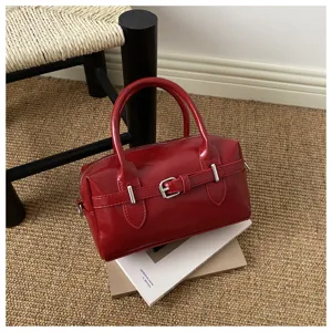 Seitenansicht einer roten Vintage-Bowlingtasche aus Leder mit silberner Schnalle