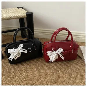 Nahaufnahme eleganter schwarzer und roter Bowling-Handtaschen mit Spitzen-Perlen-Schleifen