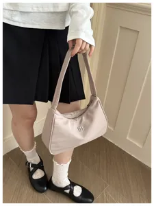 Close-up view of a stylish beige nylon underarm bag featuring metal flower accent