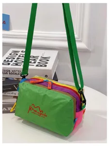 Détail d'une trousse de maquillage multicolore avec bandoulière verte réglable.