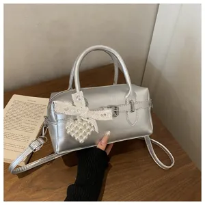 Detailansicht der silbernen Metallic-Bowlingtasche mit Perlenherz und Spitzenbogen-Deko