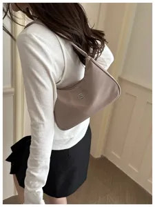 Back view of a chic mauve nylon underarm bag worn with a white long-sleeve top