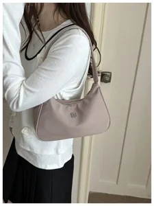 Close-up of a stylish mauve underarm shoulder bag carried by a fashion model