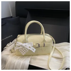 Detailansicht einer eleganten hellgelben Bowlingtasche mit Herz-Perlenanhänger
