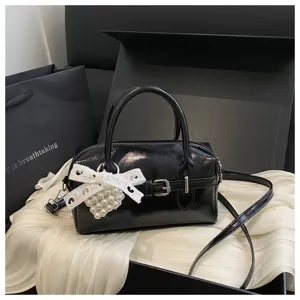 Detailansicht der schwarzen Bowling-Tasche mit eleganter weißer Spitzenschleife und Herzanhänger