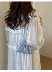 Detail of blue checkered pleated shoulder bag with a minimalist retro vibe design.