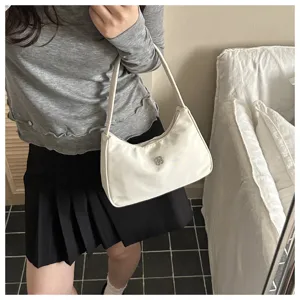 Detailed view of an elegant white nylon hobo shoulder bag featuring a silver clover metal logo