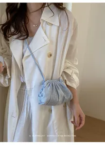Model wearing blue and white striped checkered mini crossbody bag in retro minimalist style