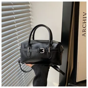 Detailansicht einer schicken schwarzen Bowling-Handtasche mit silberner Schnalle.