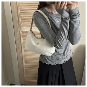 Minimalist white nylon underarm shoulder bag for women styled with a grey casual outfit