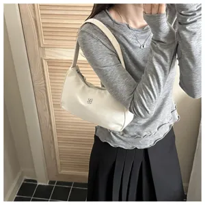 Model carrying an elegant cream white baguette shoulder bag in minimalist Korean style