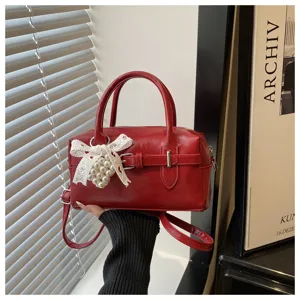 Elegante rote Bowling-Tasche mit weißer Spitzenschleife und zartem Perlenanhänger