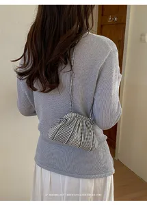 Detail of a minimalist black and white checkered small shoulder bag with strap