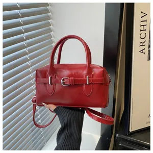 Detailansicht einer roten Bowling-Handtasche mit silbernen Schnallen und glatter Textur