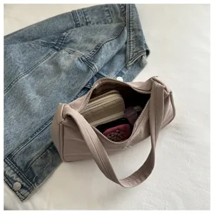 Detail view of stylish beige shoulder bag showing spacious interior and soft texture.