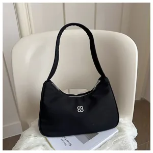 Close-up of a sleek black hobo shoulder bag with a silver decorative flower logo