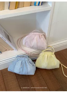 Close-up of pastel checkered pleated mini handbags in pink, blue, and yellow shades
