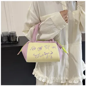 Detailaufnahme einer süßen kosmetiktasche in rosa und gelb, von einer person gehalten