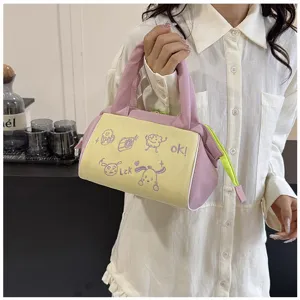 Detailansicht der niedlichen Kosmetiktasche in Pink und Gelb mit Cartoon-Stickerei