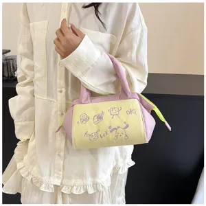 Detailansicht einer pastellrosa-gelben Kosmetiktasche mit süßer lila Stickerei