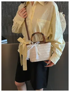 Elegante gewebte Stroh-Beuteltasche mit Naturbambusgriff und feiner Spitzenschleife.