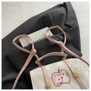 Dettaglio di un simpatico zaino marmorizzato con spalline rosa e toppa orsetto Lucky