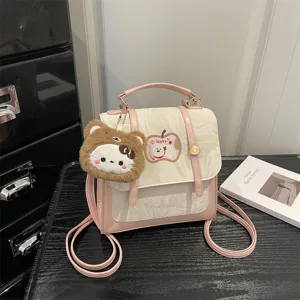 Primo piano di un elegante mini zaino rosa marmorizzato con un grazioso orsetto di peluche