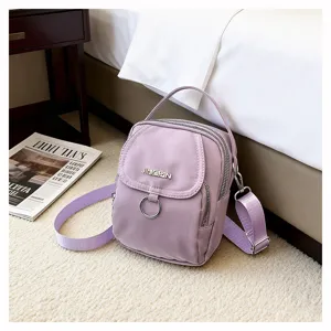 Dettaglio di una piccola borsa a tracolla in nylon lavanda in una camera da letto