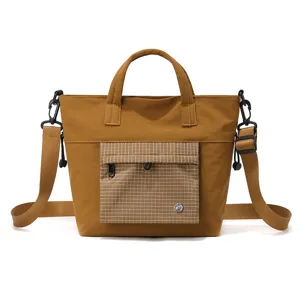 Casual brown canvas tote bag, large capacity commute shoulder bag with grid front pocket.