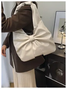 Vue détaillée d'un élégant grand sac cabas blanc cassé en forme de nœud pour femme