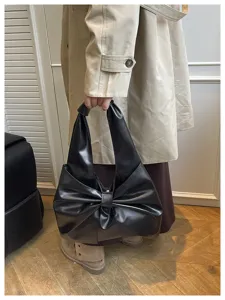 Vue détaillée d'un sac cabas noir élégant en forme de nœud pour femmes actives.