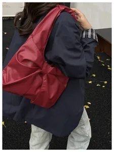 Sac fourre-tout rouge élégant avec nœud pour femme dans une scène de style urbain.