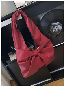 Vue détaillée d'un sac cabas avec nœud rouge foncé et texture en cuir végétalien.