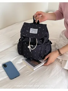 Detailed lifestyle shot of a black bow polka dot drawstring backpack for women