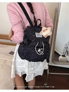 Vintage polka dot drawstring backpack worn by model in a cozy bedroom setting today