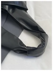 Gros plan sur le détail de la poignée nouée du sac fourre-tout noir minimaliste