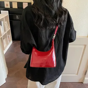 Elegant red oil wax leather crossbody bag with embossed lettering for a chic autumn look