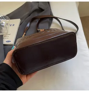 Detailed macro view of brown oil-wax leather handbag with embossed texture details
