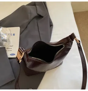 Top view detail of dark brown oil-wax leather shoulder bag with zipper opening