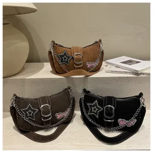 Y2K millennium style underarm baguette bags with star patches and metal chains