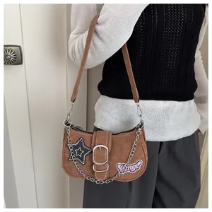 Stylish Y2K brown baguette shoulder bag with stars and silver chain detail on model