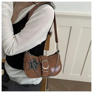 Y2K style brown underarm bag featuring star patches and decorative silver chain detail